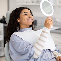 Woman smiling while looking at reflection in mirror