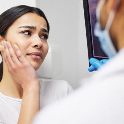 Woman with toothache talking to dentist