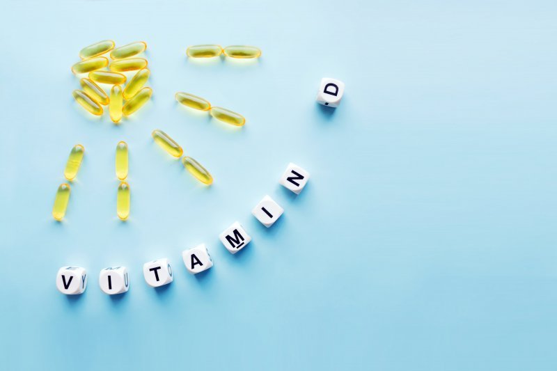 Yellow capsules in the form of a sun and the phrase “vitamin D” from white cubes